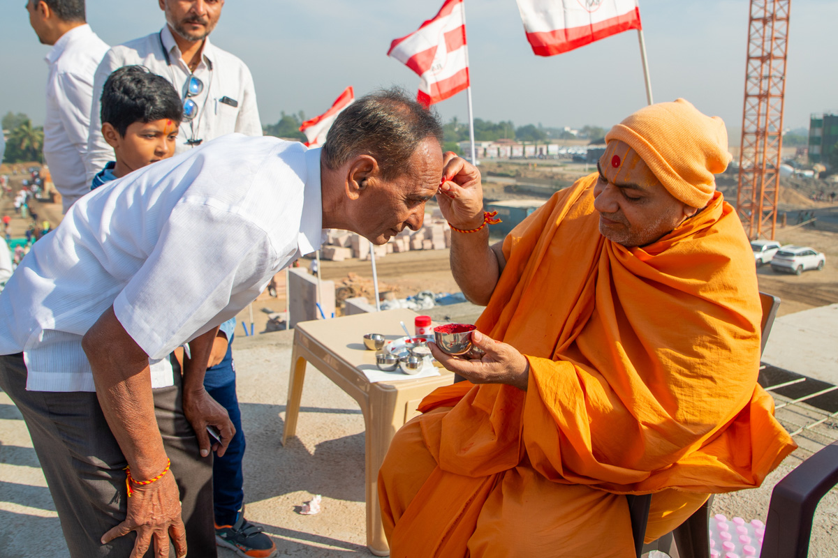 A swami applies chandlos to devotees