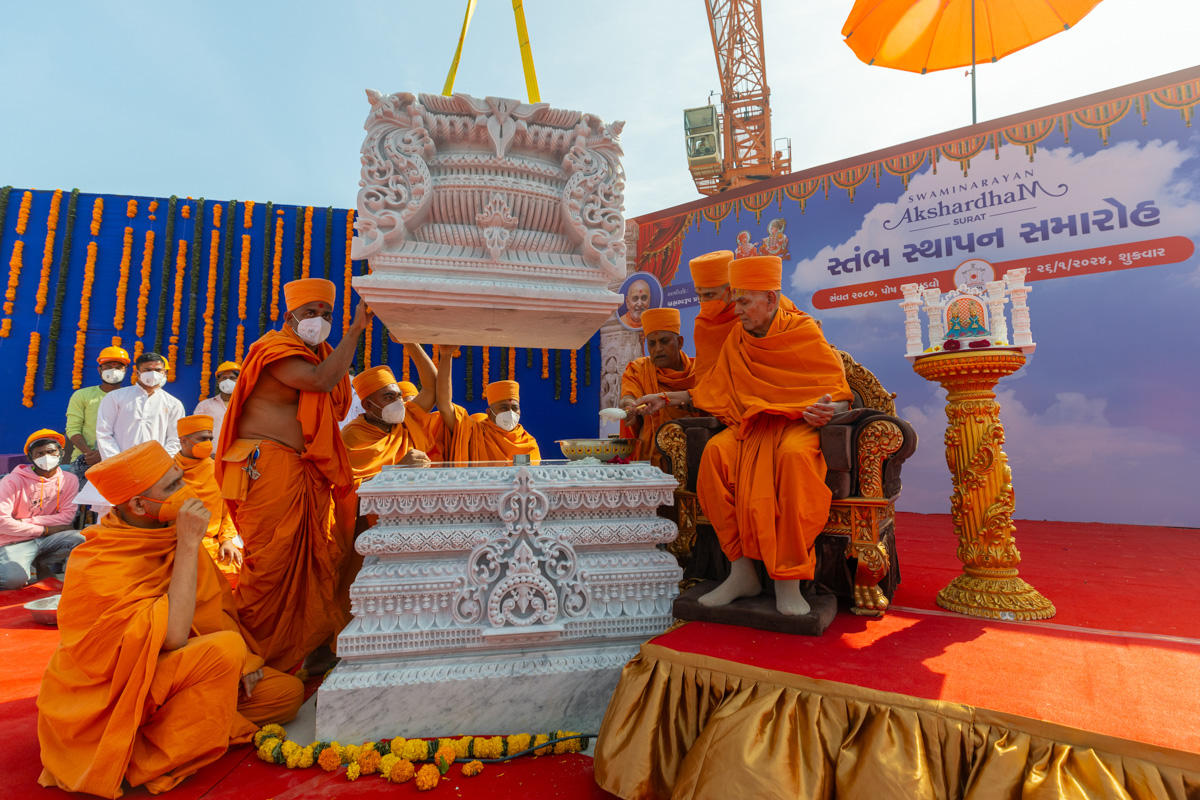 Swamishri pours cement on the pillar base