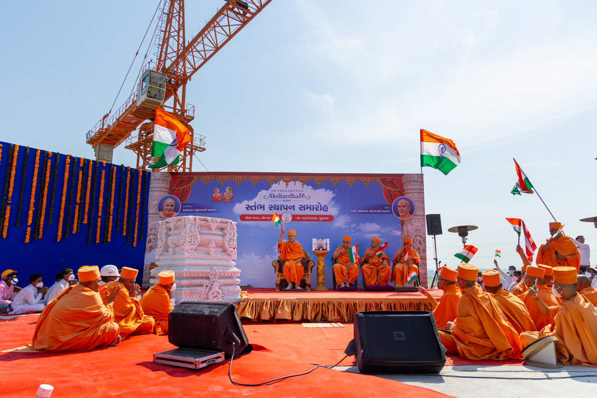 Swamishri and senior swamis wave Indian flags