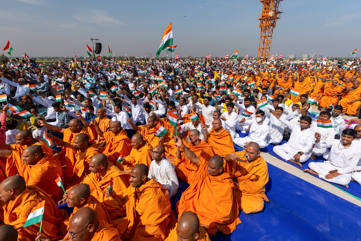 Swamis and devotees wave Indian flags