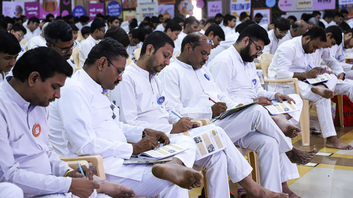 Bal karyakars take notes in their codebooks