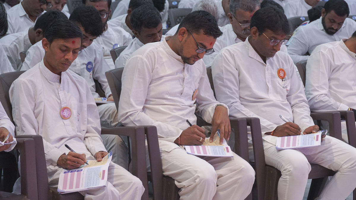 Bal karyakars take notes in their codebooks