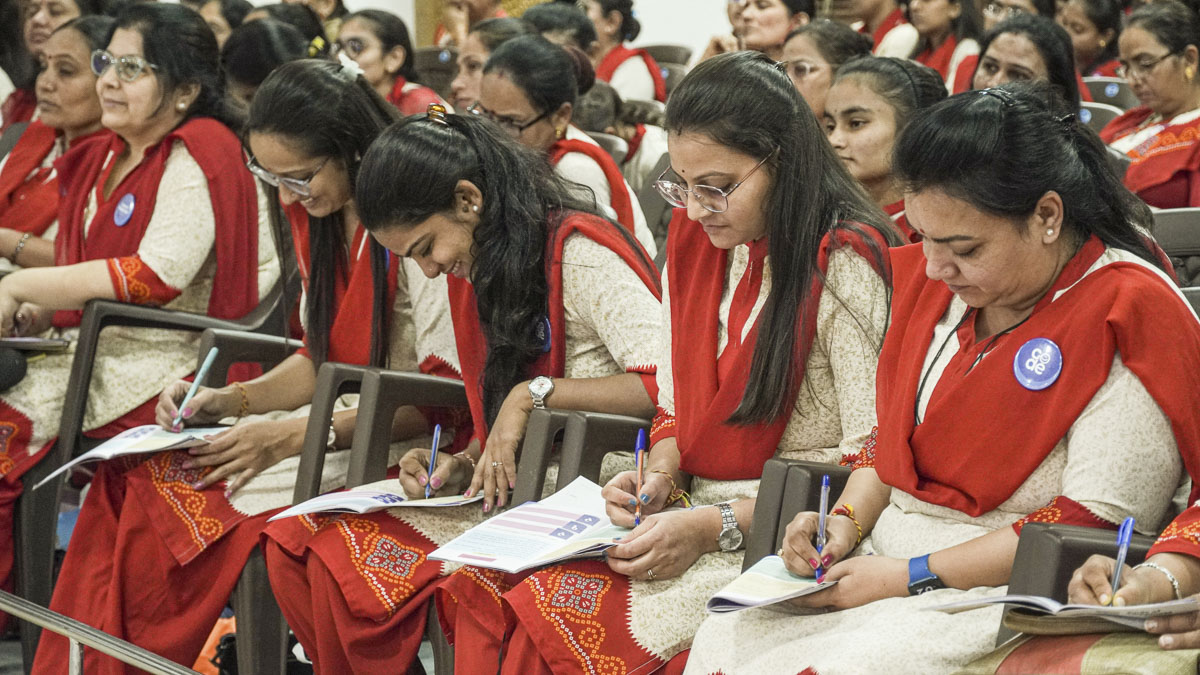 Balika karyakars take notes in their codebooks
