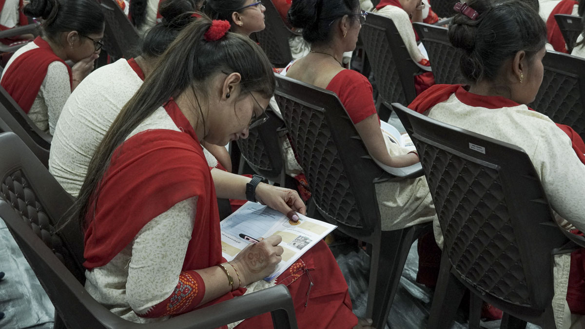 Balika karyakars take note of important points in their codebooks