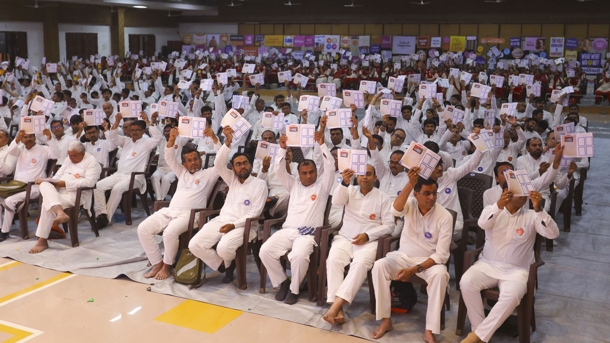 The karyakars pledge to Mahant Swami Maharaj that they will dedicate themselves 100% toward their sevas