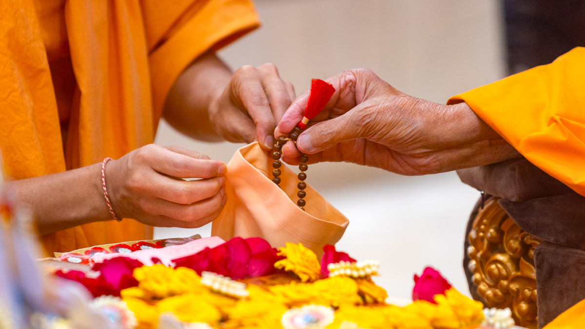 Swamishri prepares to turn the mala in his puja