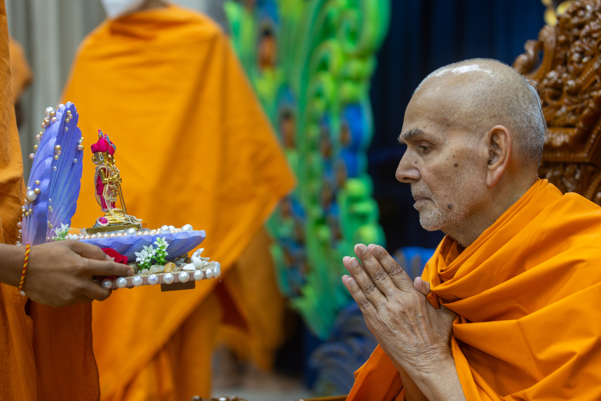 Param Pujya Mahant Swami Maharaj engrossed in darshan of Shri Harikrishna Maharaj and Shri Gunatitanand Swami Maharaj