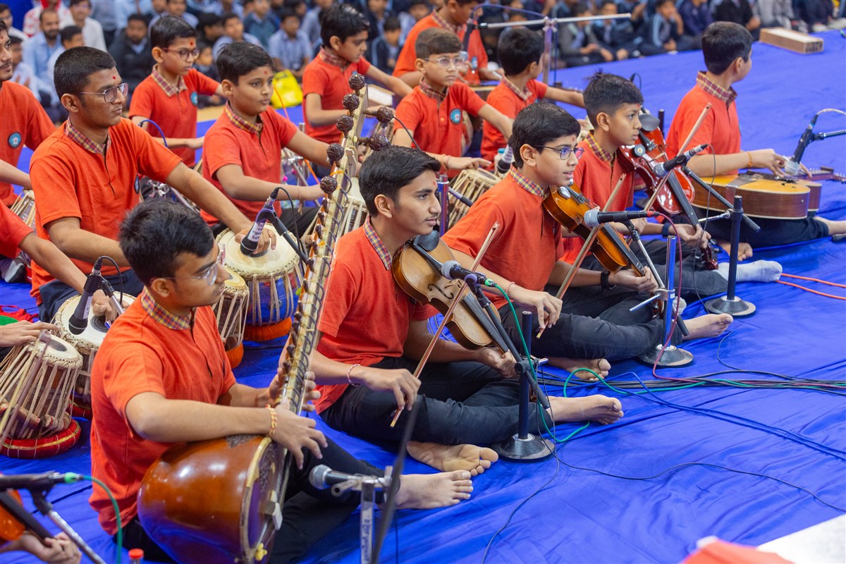 Students play musical instruments in Swamishri's morning puja