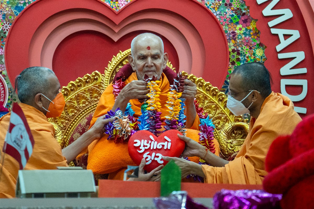 Swamis honor Swamishri with a garland 