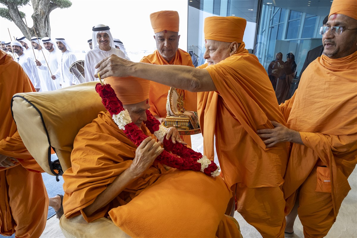 Sadguru Pujya Ishwarcharandas Swami greeted Swamishri with a garland of fresh flowers