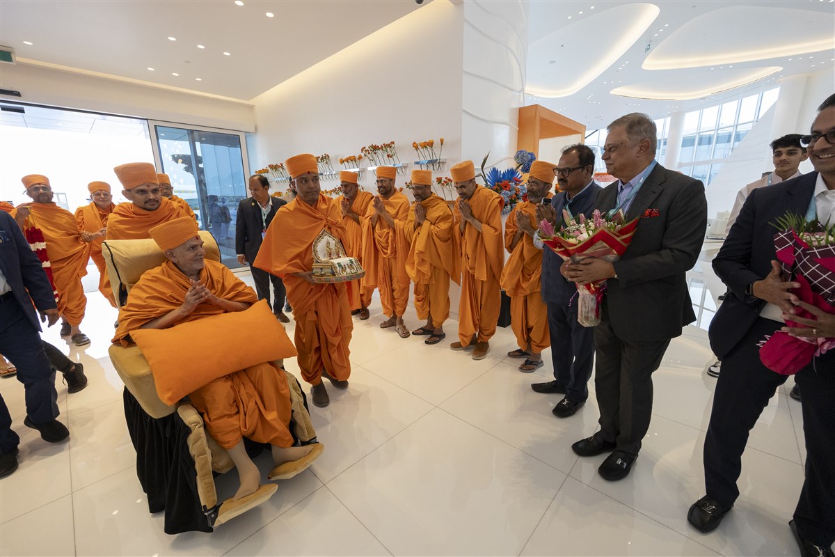 Swamishri made his way through the airport humbly accepting the warm welcome with folded hands