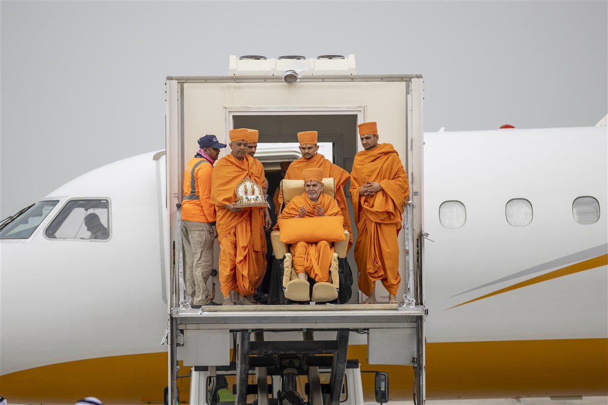 As Swamishri descended from the plane...