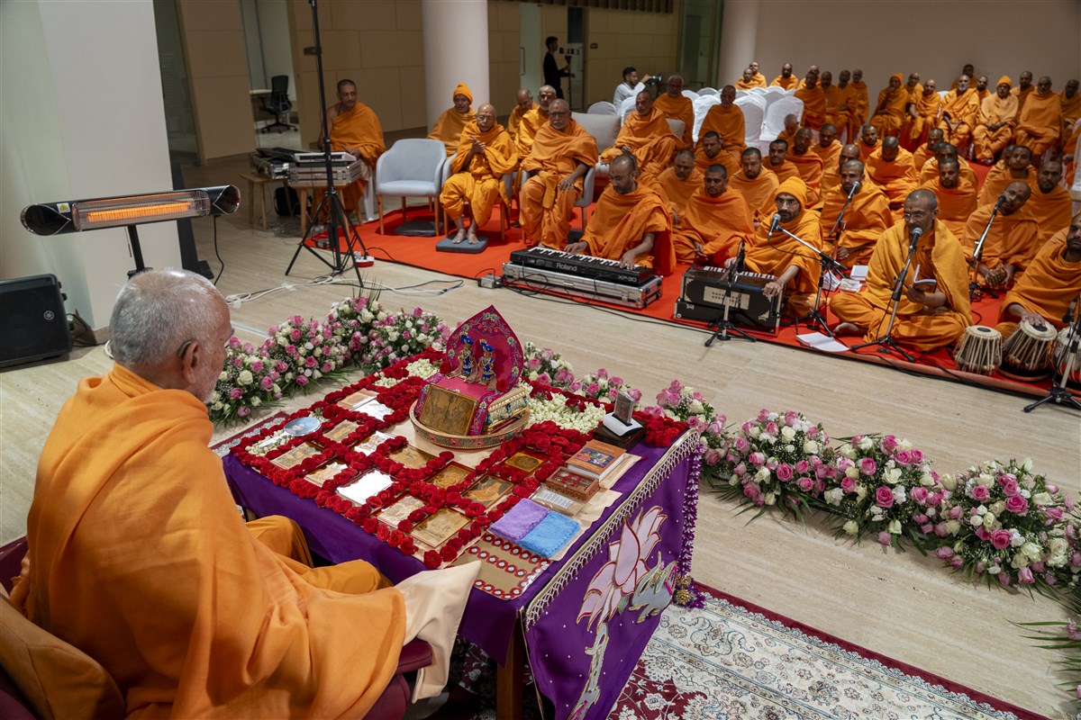 Swamis sing kirtans while Swamishri performs his puja