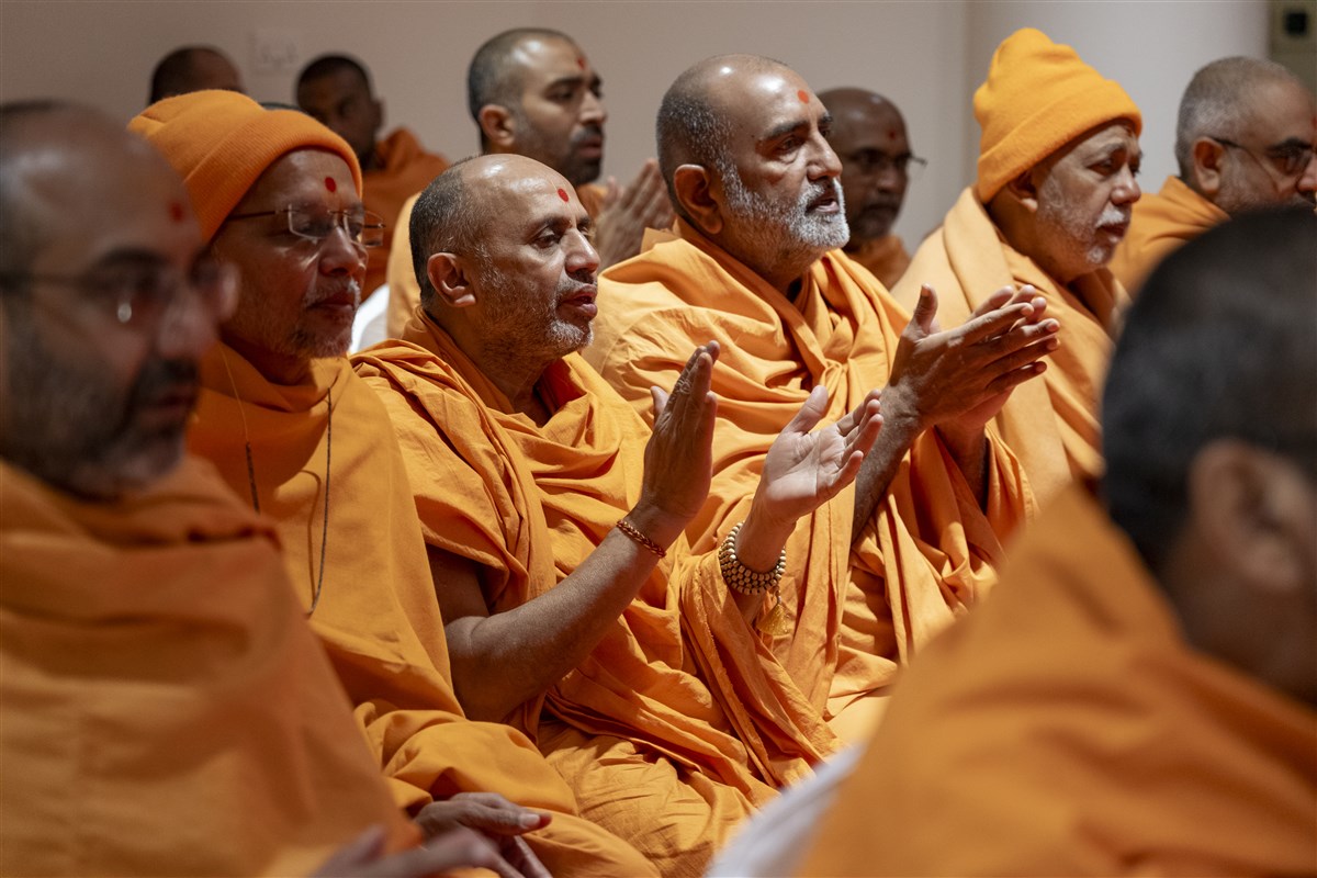 Swamis engrossed in Swamishri's darshan as he performs his puja