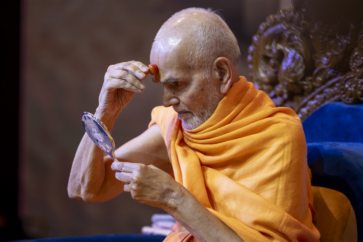 Swamishri applies a chandlo within the tilak