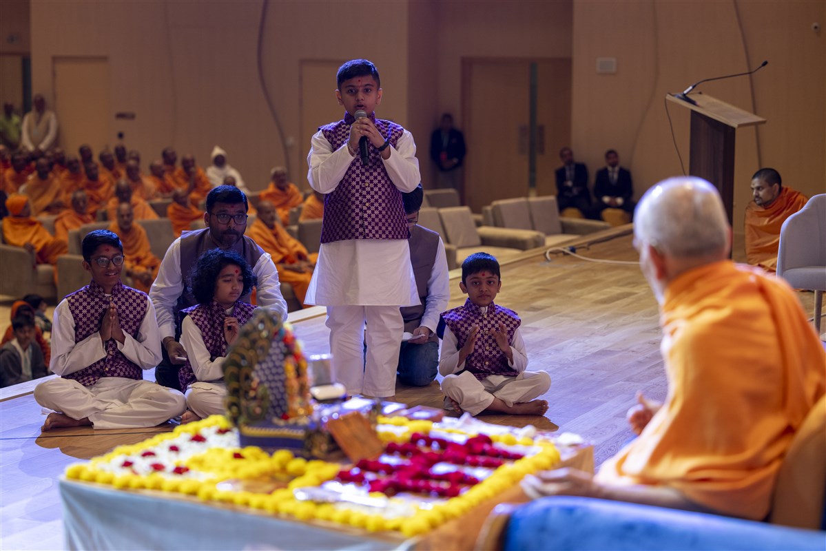 A child recites scriptural passages during Swamishri's puja