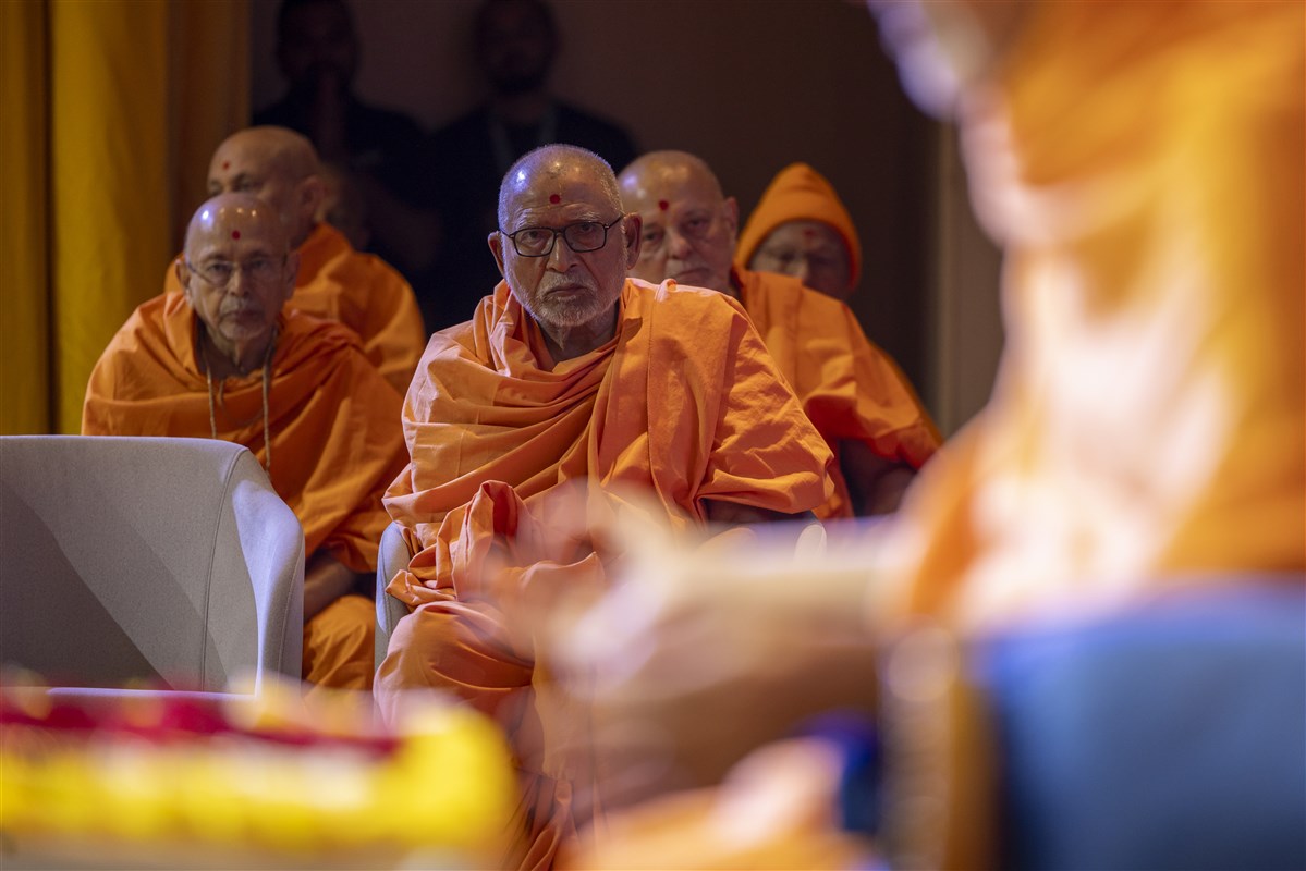 Senior swamis engrossed in Swamishri's puja darshan