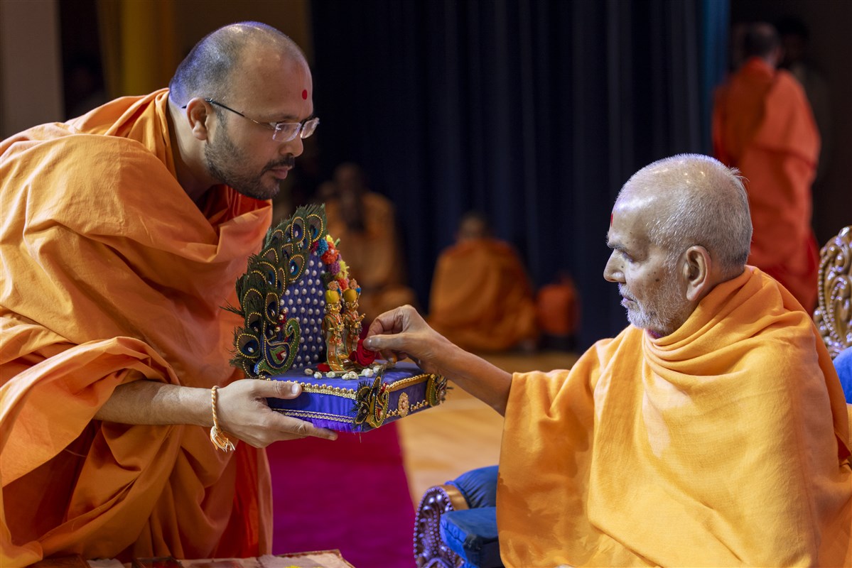 Swamishri offers rose to Shri Harikrishna Maharaj and Shri Gunatitanand Swami Maharaj