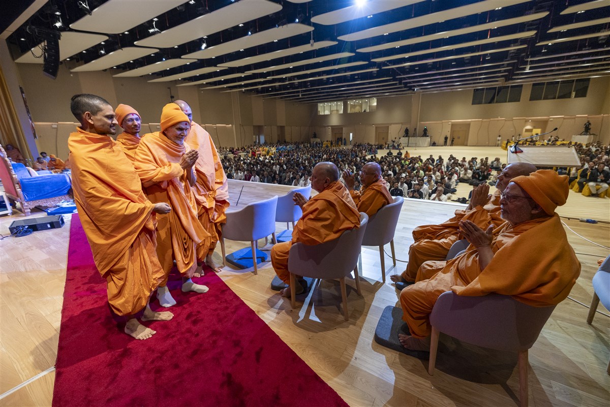Swamishri greets senior swamis with folded hands as he departs from the morning assembly