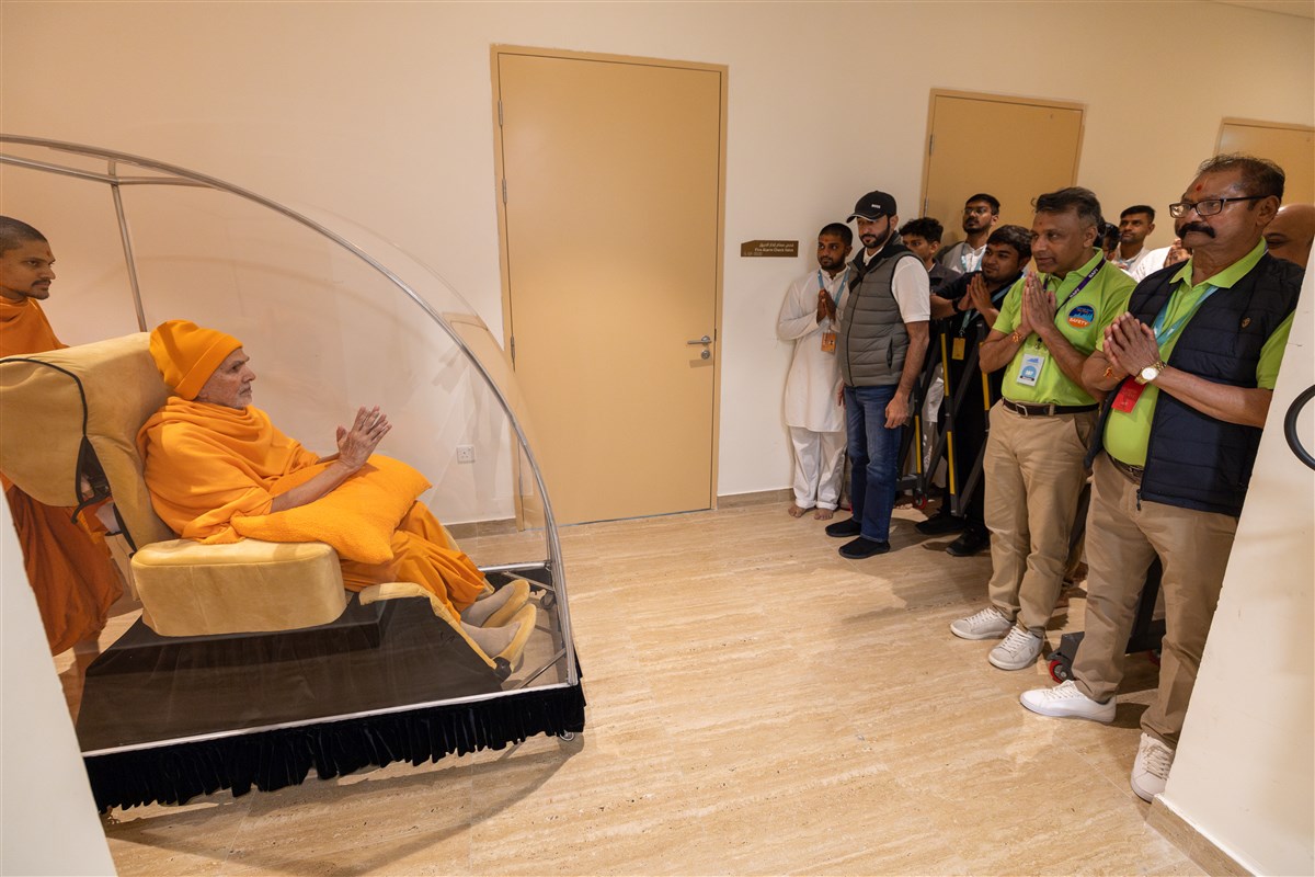 Swamishri blesses devotees and volunteers on his way to his morning puja