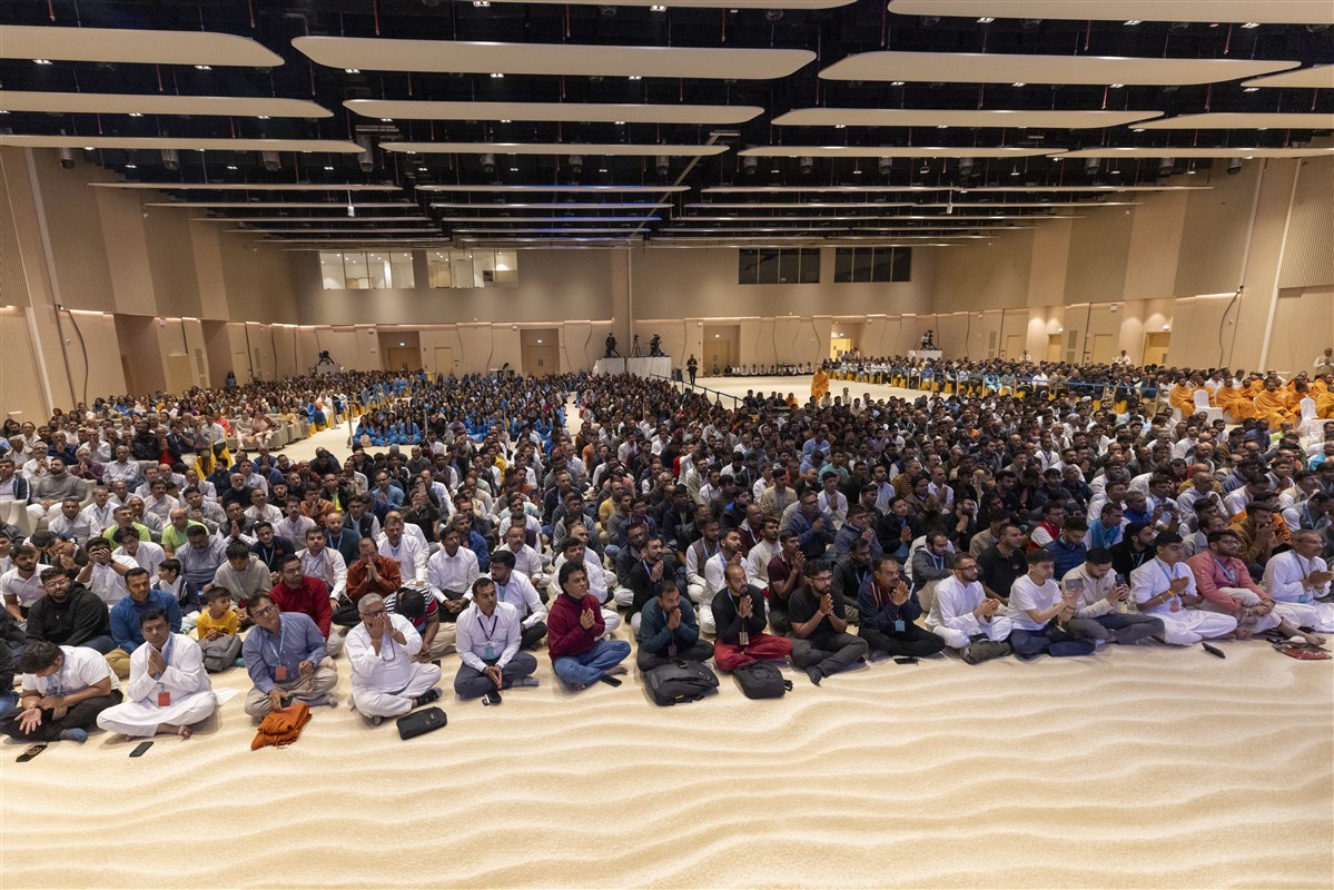 Devotees engrossed in Swamishri's darshan with folded hands