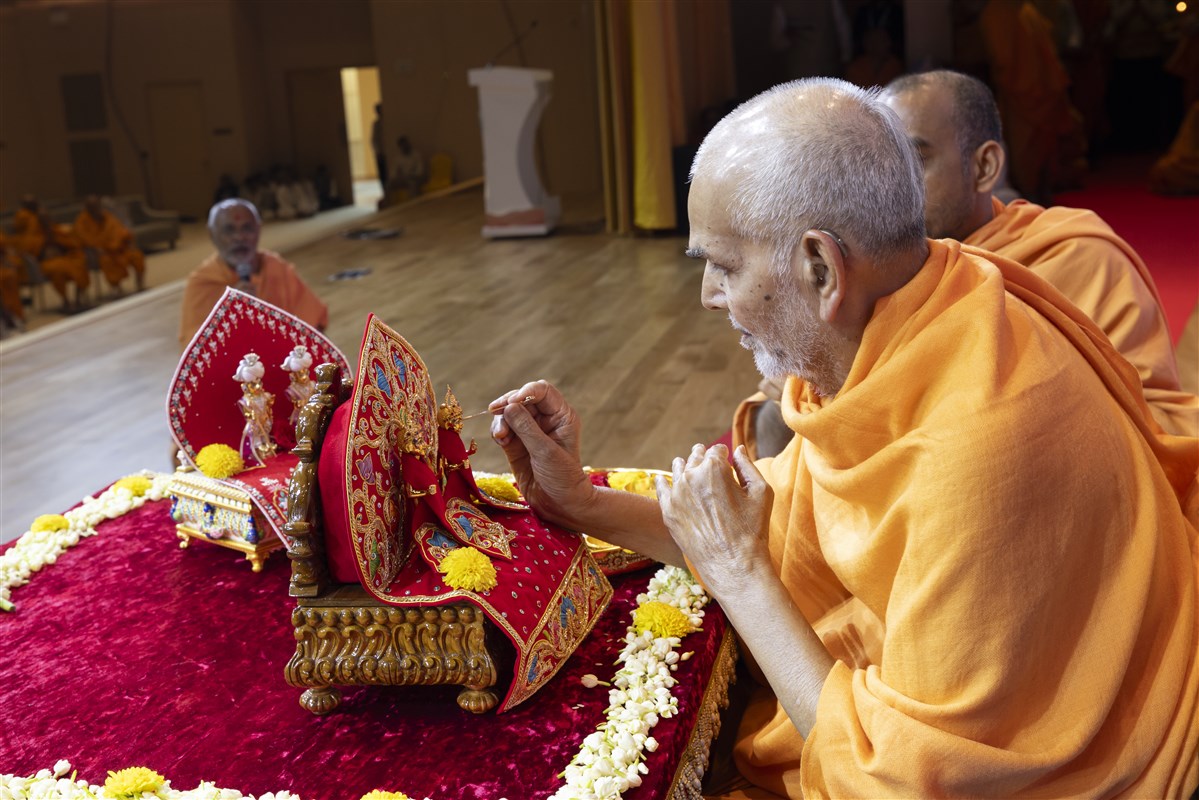Swamishri applies a chandlo to Shri Gunatitanand Swami Maharaj