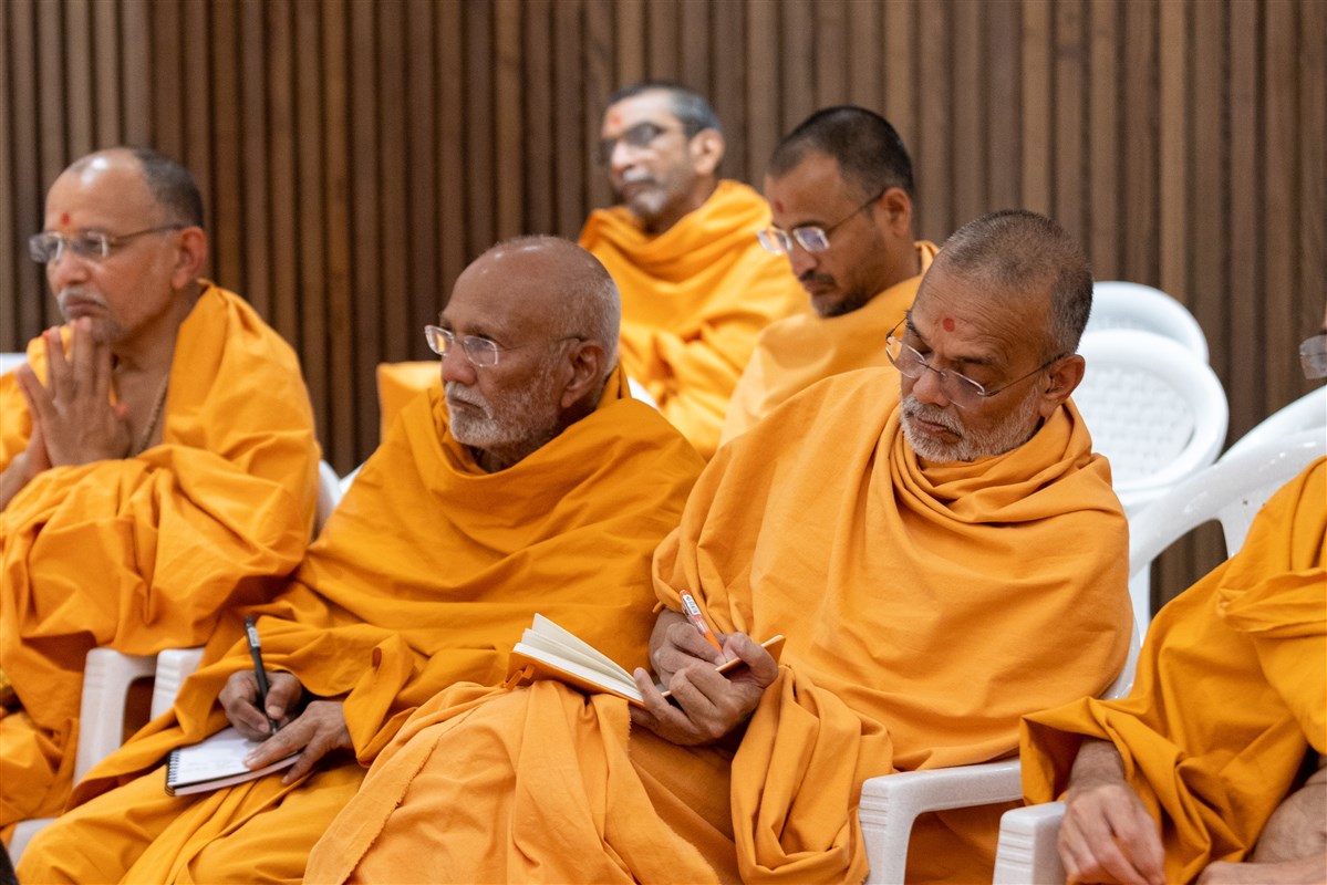 Swamis make notes from Swamishri's discourse