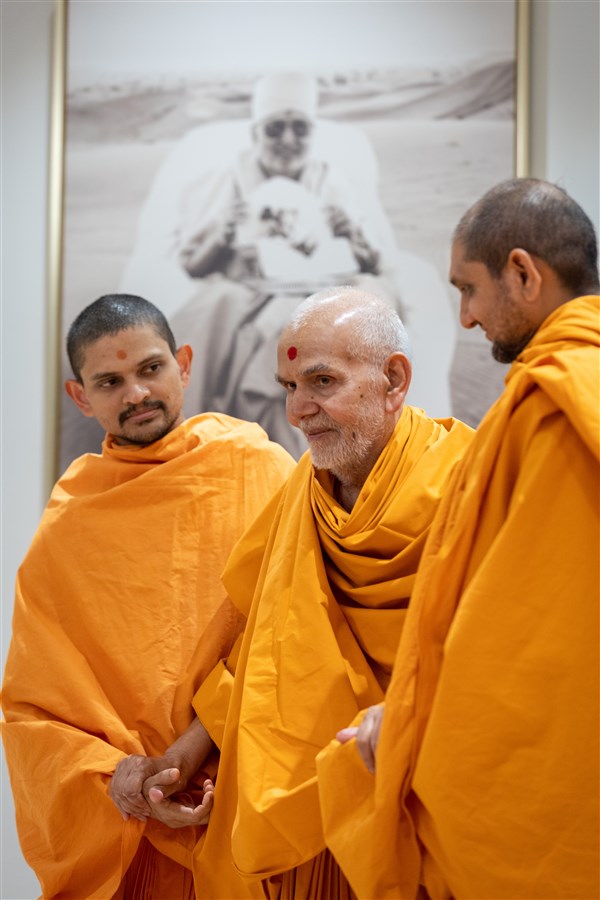 Swamishri shares a smile as he departs the afternoon assembly