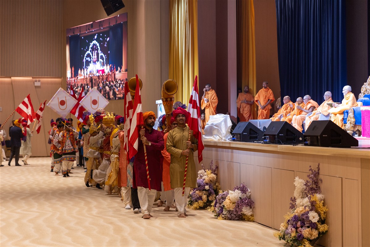 The welcome procession passes Swamishri and the sadguru swamis on the stage