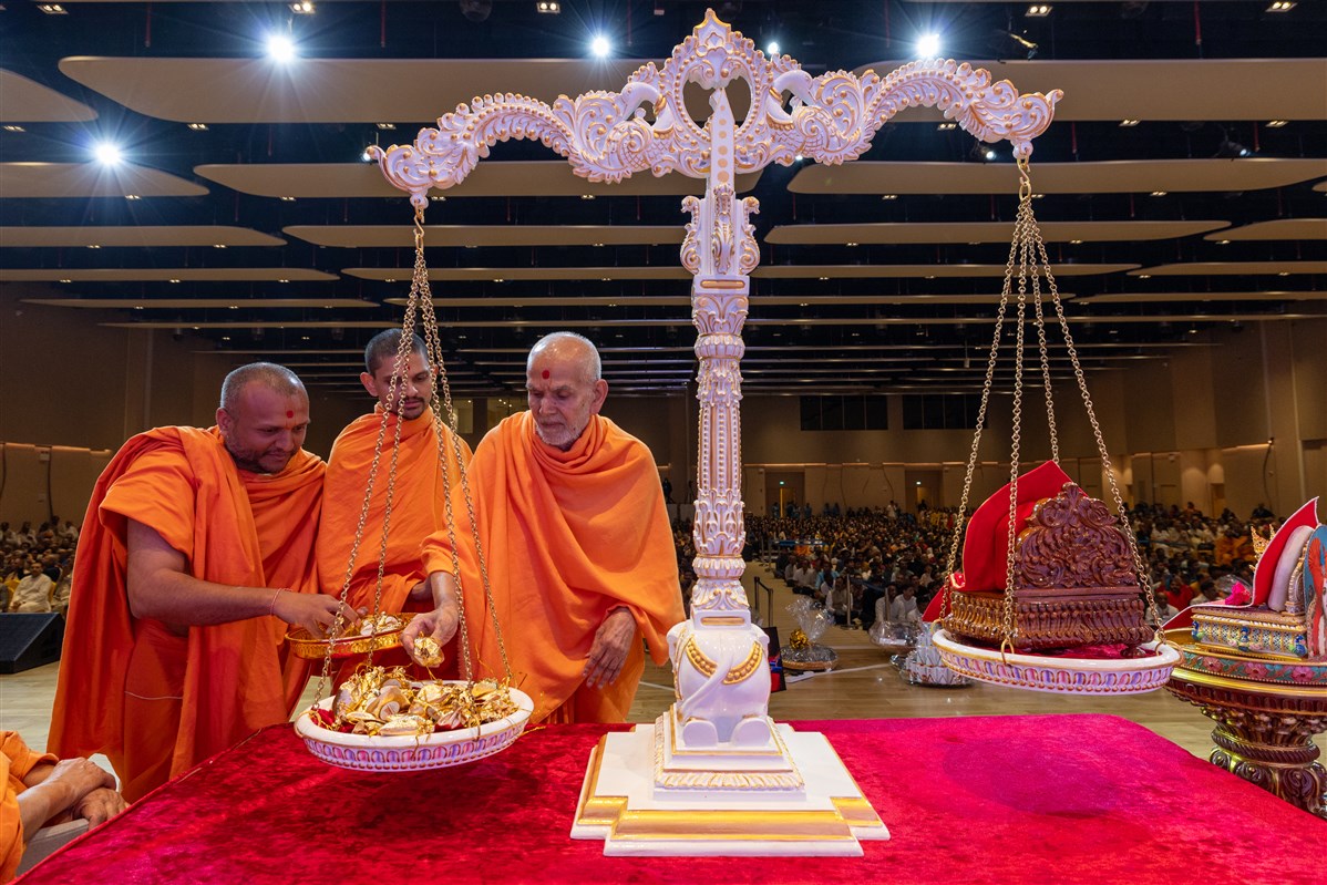 Swamishri places a bag of rosary beads as an offering in the devotional scales<p></p>Learn more about the ‘Day of Devotion’ <a href="https://www.baps.org/News/2024/Day-of-Devotion-25361.aspx" target="blank" style="text-decoration:underline; color:blue;">here</a>