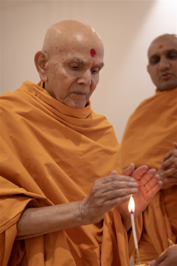 Swamishri accepts the blessings from the arti