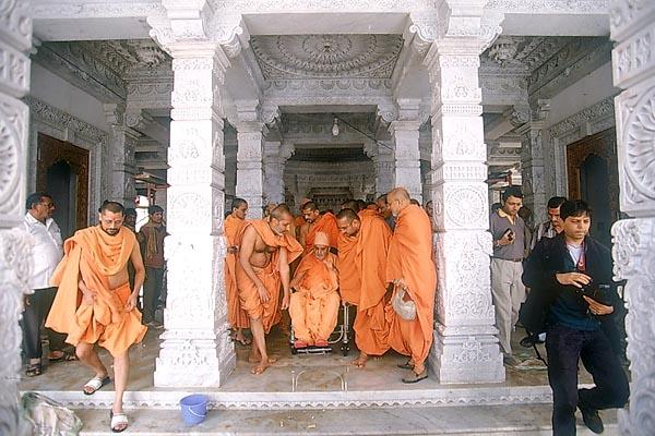 Swamishri being brought towards the mandir podium