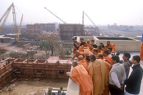  Swamishri and sadhus observe the under construction Akshardham complex