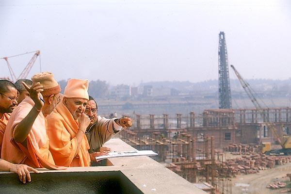  Swamishri and sadhus observe the under construction Akshardham complex