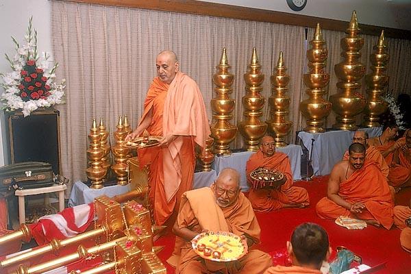 Swamishri and senior sadhus perform arti of kalashas and the murtis to be installed at the Hari mandir in Gujarat Vihar