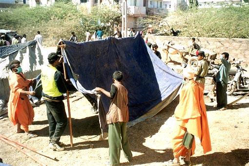  Volunteers and sadhus erecting a tent... 