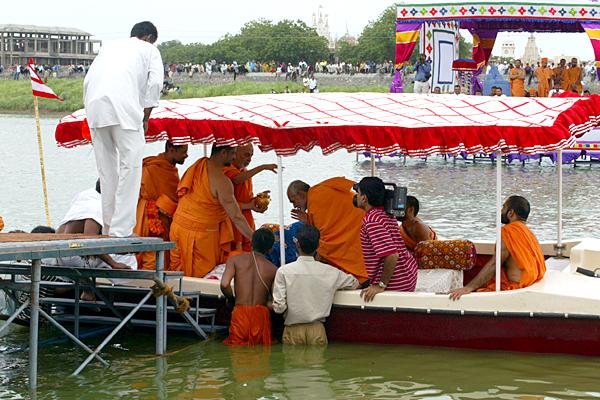 Swamishri sprinkles holy water on Mahant Swami