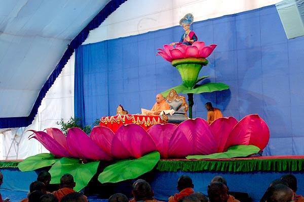 Swamishri performs his morning puja on a decorative lotus stage 	