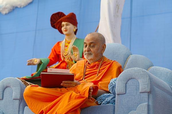 Swamishri writes letters during an assembly