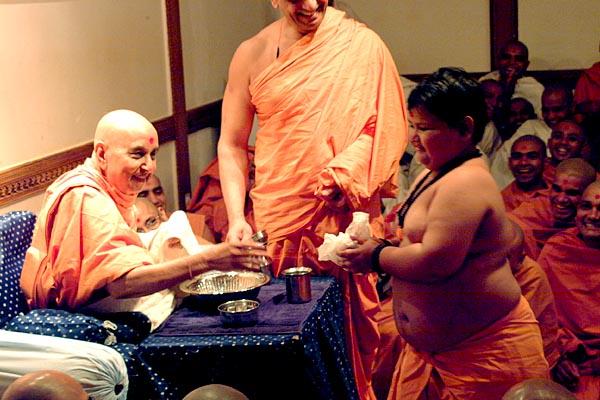 Swamishri happily gives prasad to a fat balak