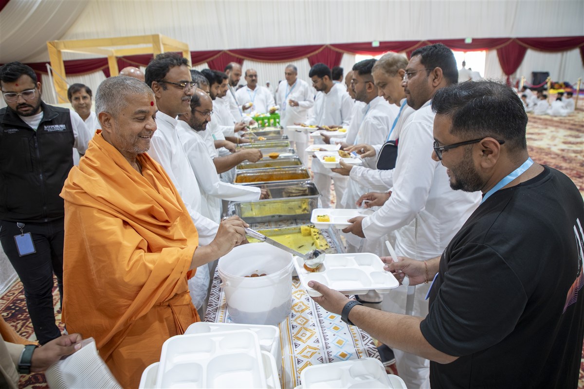 Swami Brahmaviharidas lovingly serves lunch to the shibir attendees