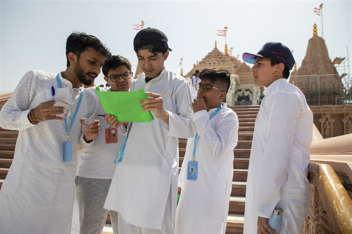 Teenagers participate in the treasure hunt across the mandir premises