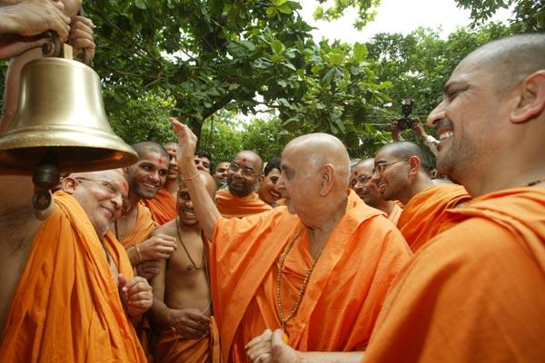 Swamishri happily ringsthe bell in honor of the chimes of Akshar Purushottam philosophy spread by Shastriji Maharaj