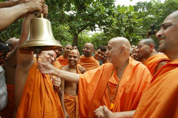 Swamishri happily rings the bell in honor of the chimes of Akshar Purushottam philosophy spread by Shastriji Maharaj