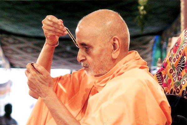 Swamishri applies tilak during his morning puja 