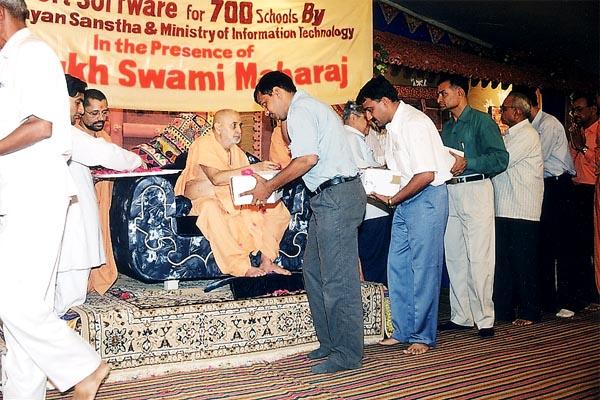 Swamishri distributes the free software packages to school officials