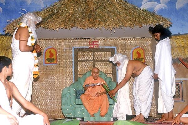 Swamishri lights an inaugural lamp and is welcomed by youths dressed as Bhrugu Rishi and other sages after his arrival
