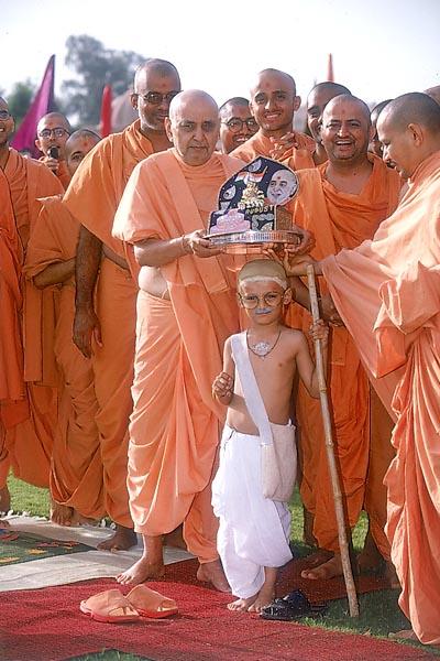 Swamishri places Shri Harikrishna Maharaj on the balak