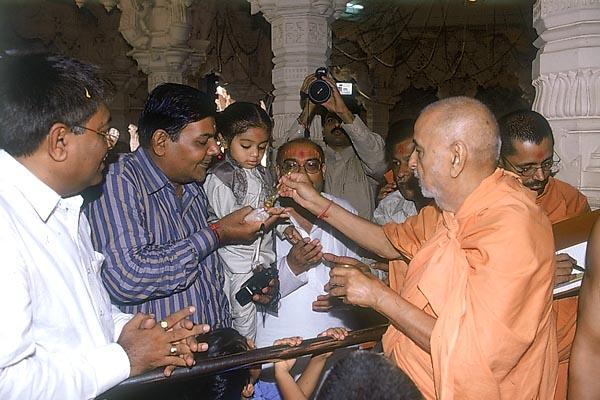 Swamishri gives water to even a balak during a ritual