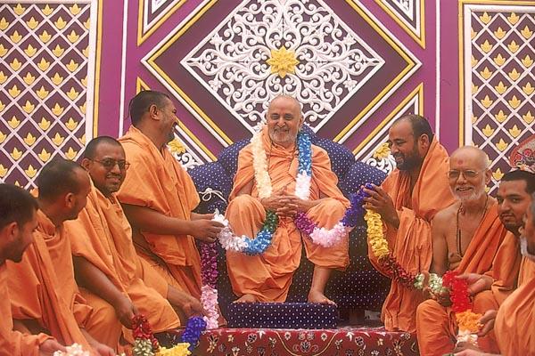 Sadhus of Surendranagar offer a garland to Swamishri